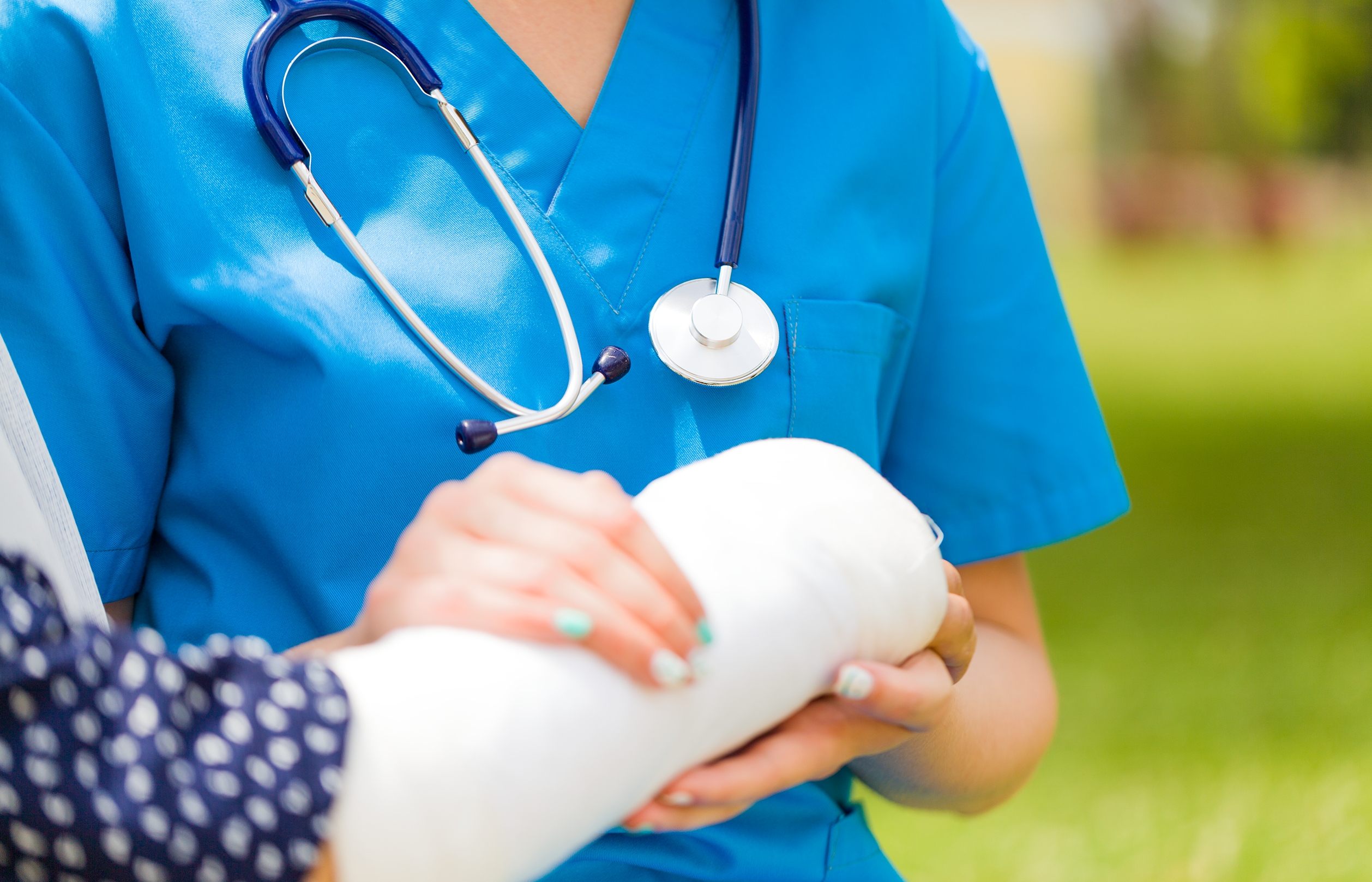 Closeup of holding hands for convalescence of old woman's broken arm bone with bandage.